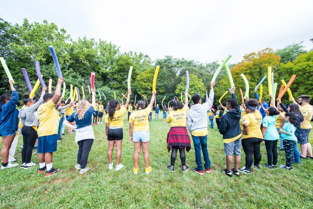 Students in a circle holding pool noodles