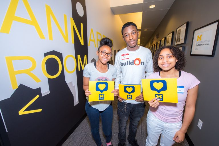 Students holding U-M admissions booklets at the Detroit Center