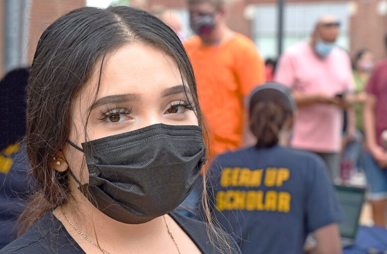 Student poses with a cloth face mask at a GEAR UP event.